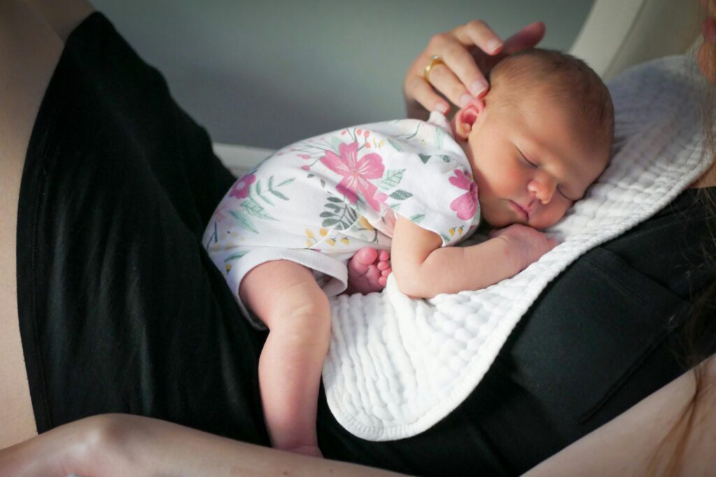 Bebê Reborn deitando no colo da sua mãe.